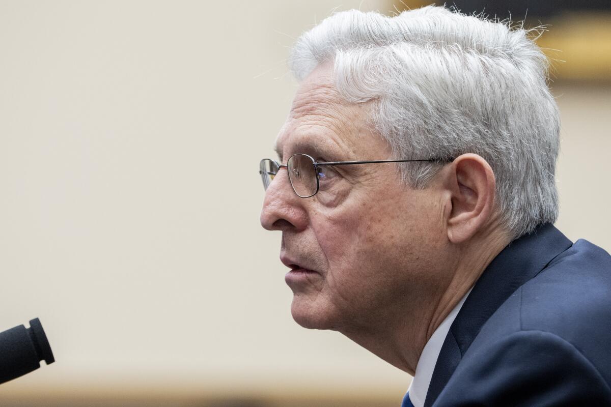 Atty. Gen. Merrick Garland pictured in profile as he speaks into a microphone.