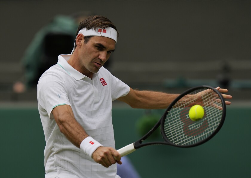Roger Federer plays a return during the men's singles third-round match at Wimbledon.