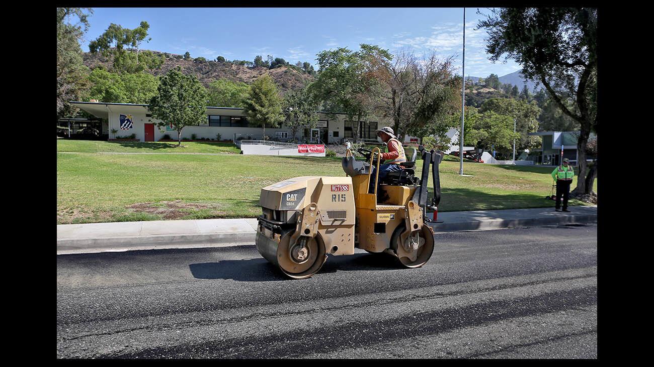 Construction workers lay down new rubberized asphalt on Knight Way in front of Paradise Canyon Elementary School on Tuesday, Aug. 14, 2018. 900 linear feet of the street was covered with new asphalt and 1100 linear feet of asphalt on Gould Ave, was also replaced.