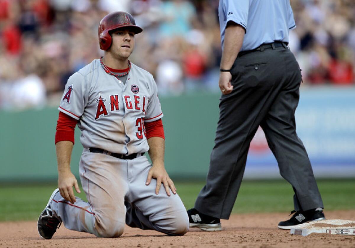 Angels outfielder J.B. Shuck kneels on the infield after being tagged out when he was caught in a rundown between second and third during the eighth inning against the Boston Red Sox.