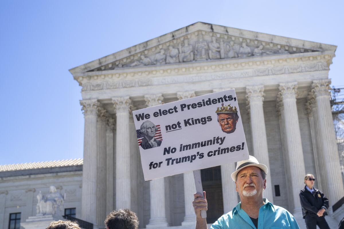 A man holds a sign outside the Supreme Court: "We elect Presidents, not Kings."