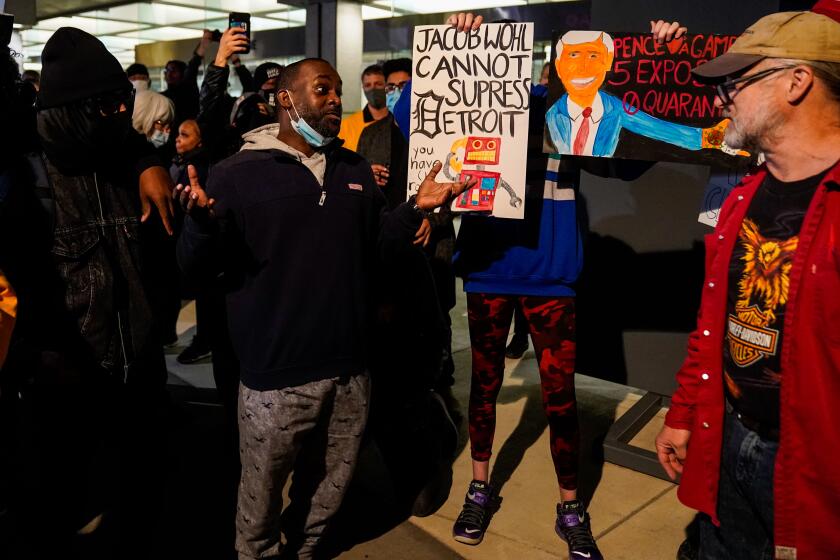 DETROIT, MI - NOVEMBER 04: Maceo Rhodes, 34, of Detroit, talks with a supporter of Donald Trump at the Detroit Department of Elections Central Counting Board of Voting absentee ballot counting center at TCF Center, Wednesday, Nov. 4, 2020 in Detroit, MI. With the surge in vote by mail/absentee ballots, analysts cautioned it could take days to count all the ballots, leading some states to initially look like victories for President Trump only to later shift towards democratic Presidential candidate Joe Biden. (Kent Nishimura / Los Angeles Times)