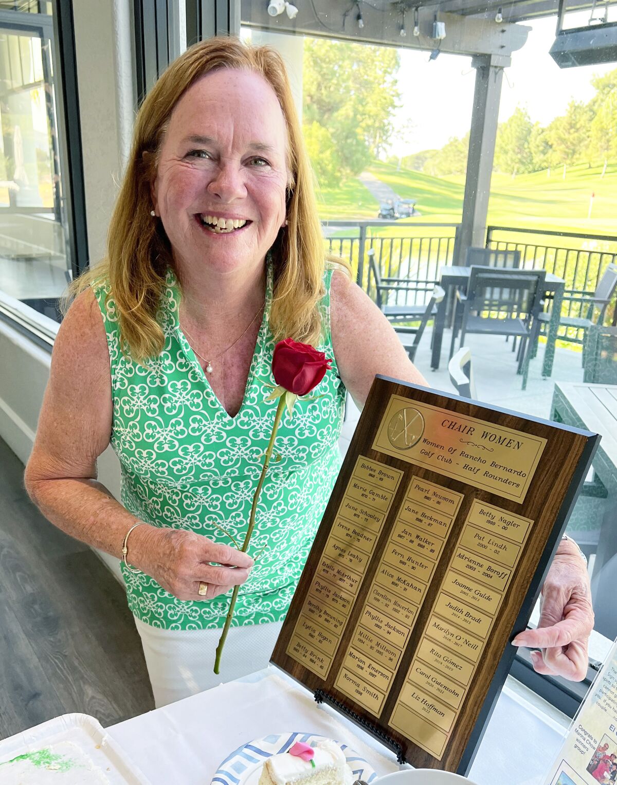 Lady Niners Chair Liz Hoffman with a plaque listing her predecessors over the group’s 55 years.