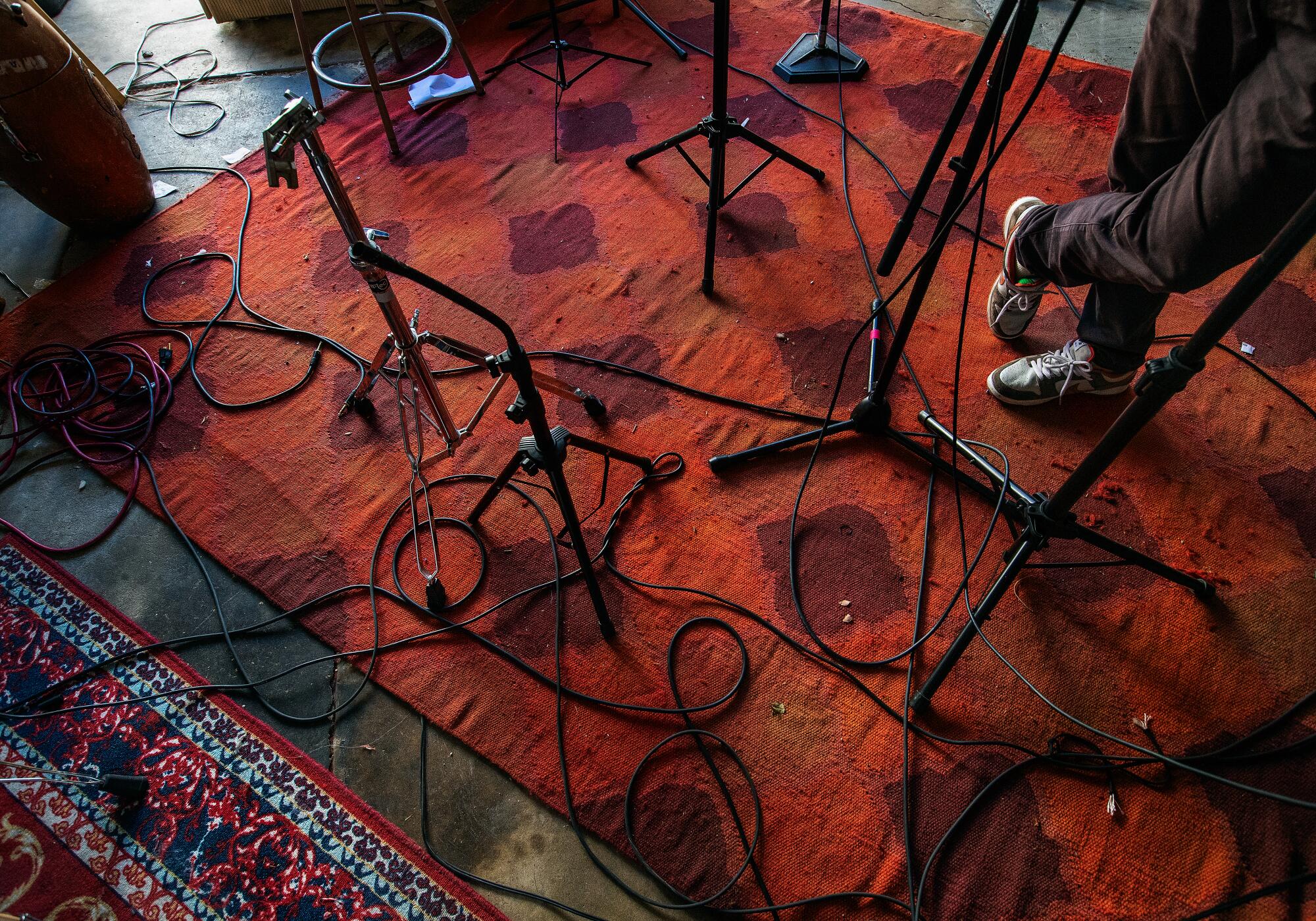 An image of a red carpeted floor, covered in cables and mic stands.