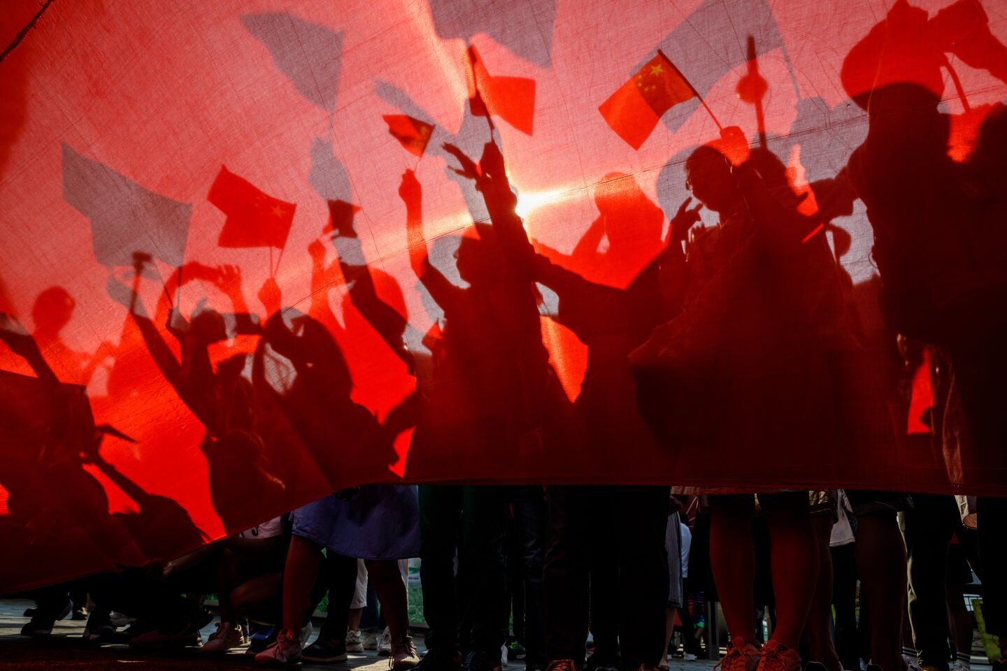 A few dozen people unfurl a large China flag and gather around it to commemorate China's national dayin Hong Kong.