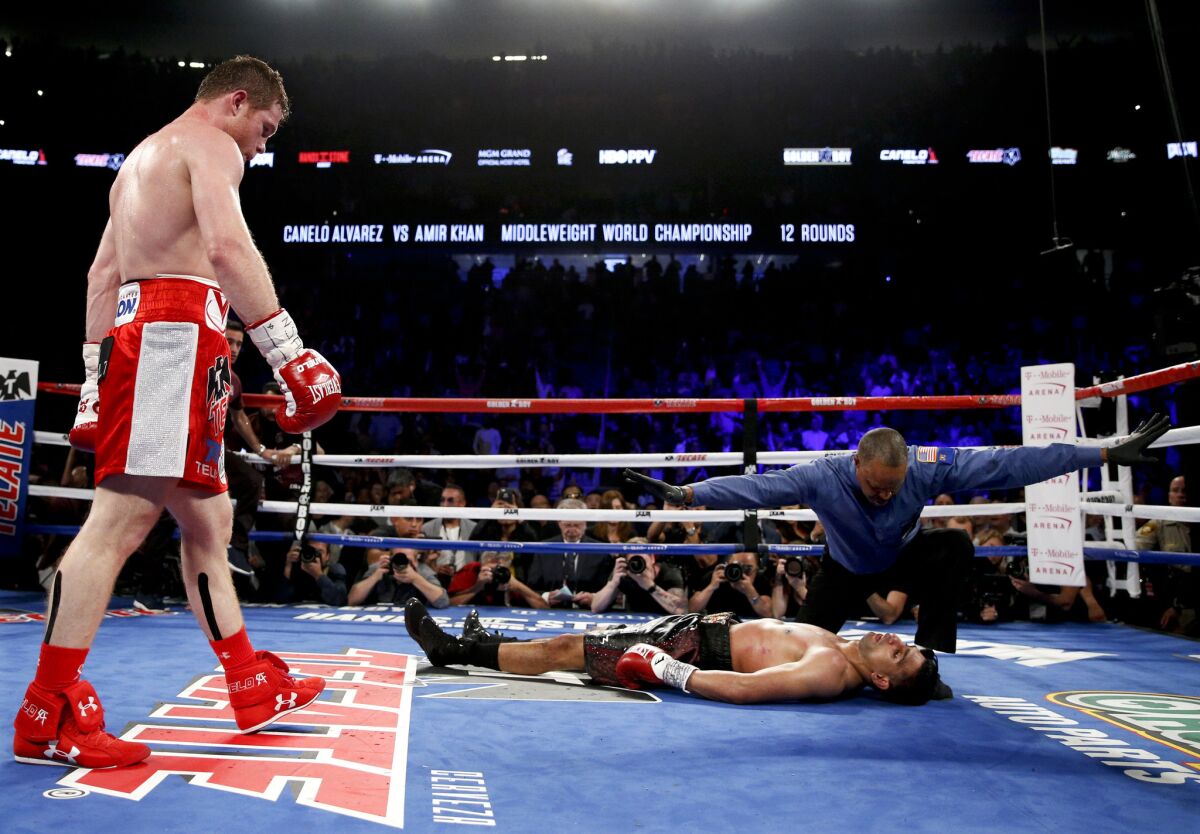 El boxeador mexicano Saúl "Canelo" Alvarez, izquierda, observa a Amir Khan tras noquearlo en un combate el 7 de mayo de 2016 en Las Vegas.