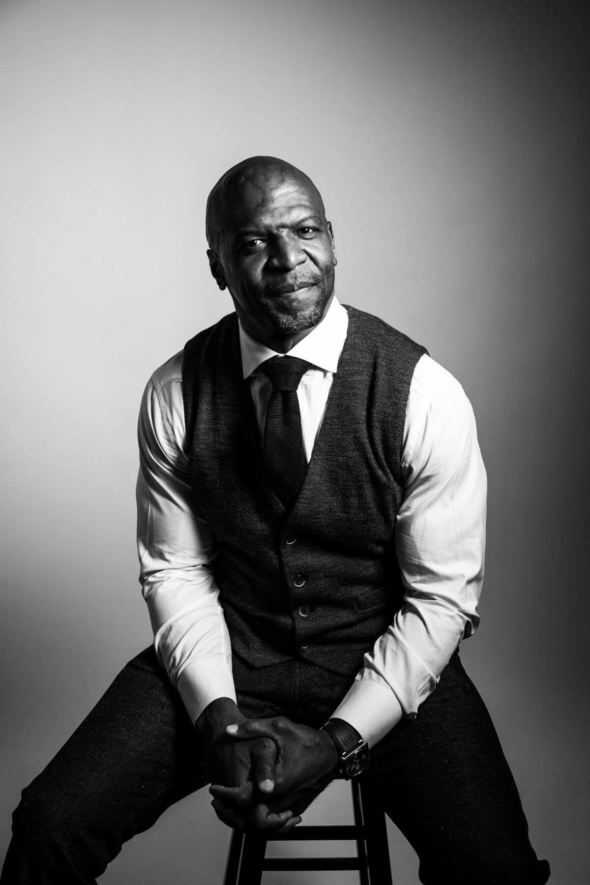 A black-and-white studio portrait of Terry Crews, looking thoughtful.