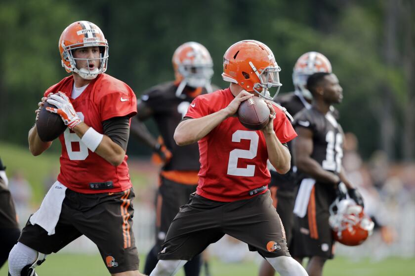Cleveland quarterbacks Brian Hoyer, left, and Johnny Manziel drop back to pass at training camp Saturday in Berea, Ohio.