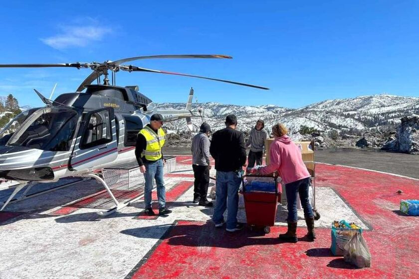 Lisa Griggs, resident in Lake Arrowhead, is part of CalDART (Disaster Airlift Response Team) who delivered supplies to snowed-in residents via helicopter air drops on Friday, March 3, 2023. San Bernardino County Sheriff Dept. redirected the helicopter from a Lake Gregory store parking lot to an "approved" landing zone, according a SBCSD official twitter post.