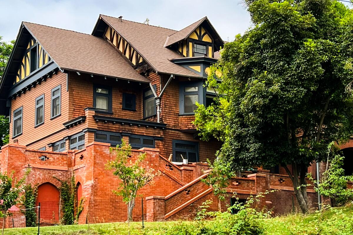 A wood-shingled mansion with many windows