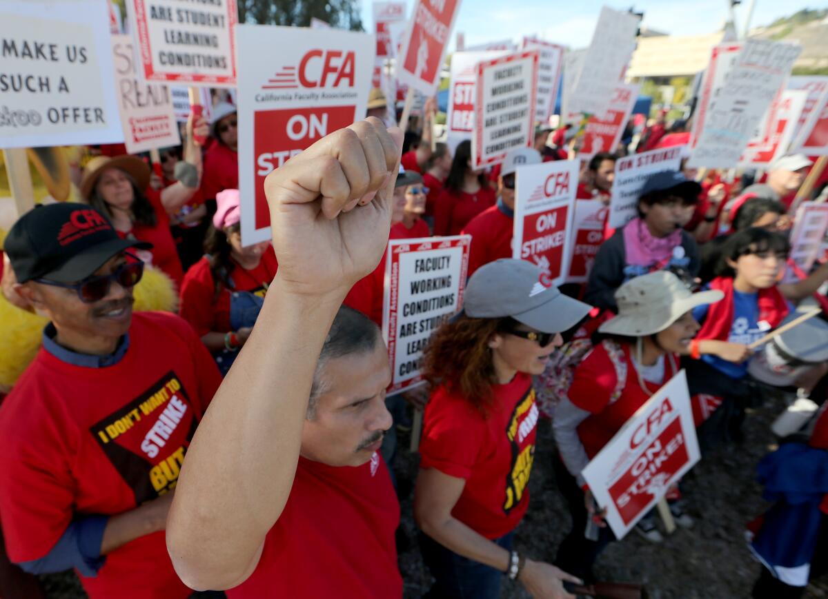 Cal-Poly Pomona faculty strike on campus holding signs and wearing red shirts. 