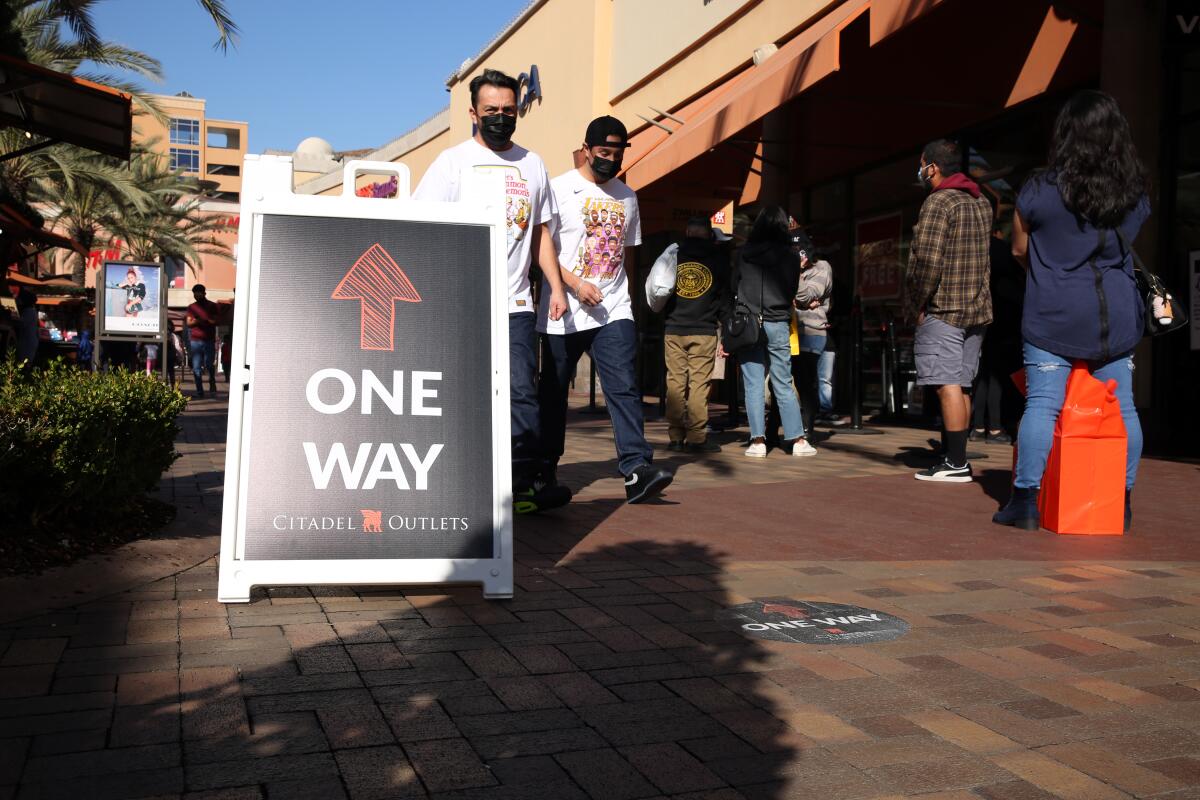 People walk against the suggested flow of foot traffic at the Citadel Outlets in Commerce on Tuesday.