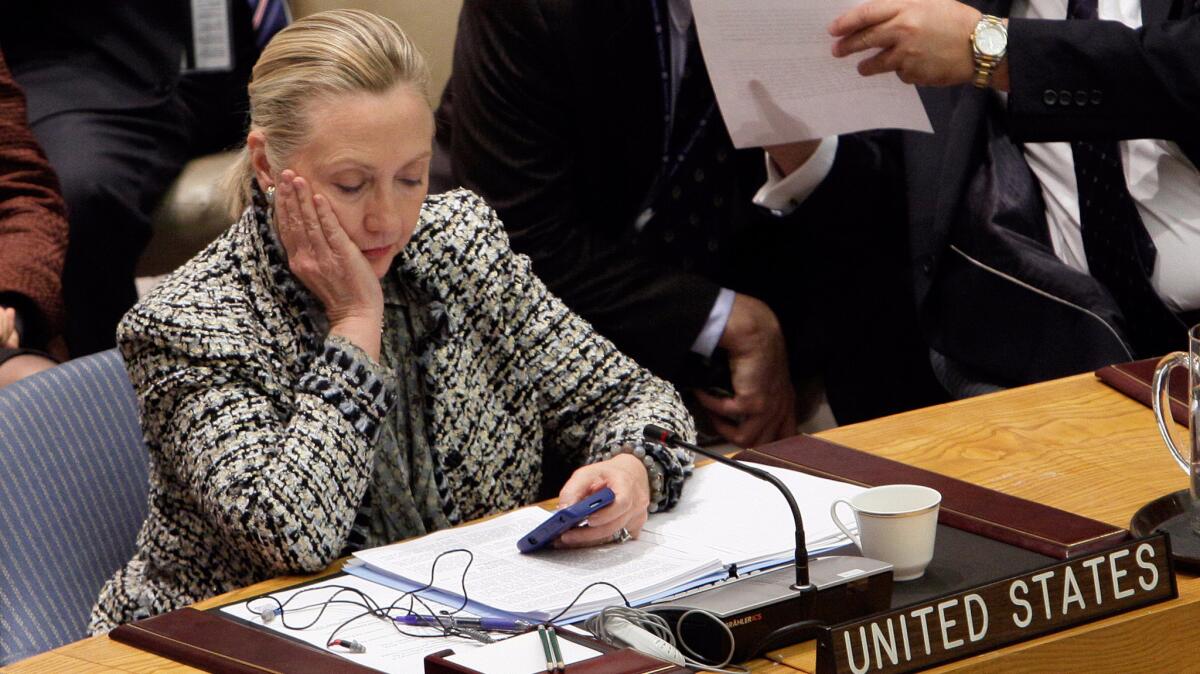 Then-Secretary of State Hillary Clinton checks her mobile phone after her address to the Security Council at United Nations headquarters in 2012. The investigation into the presidential candidate's use of a private email server has continued to dog her campaign.