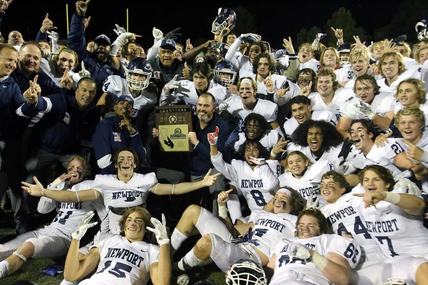 Newport Harbor's head coach Peter Lofthouse, center, holds the CIF 2021 Championship plaque as he poses with his team the Newport Harbor Sailors after winning the CIF Southern Section Division 6 Championship game 42-35 against Temecula Valley at Temecula Valley High School in Temecula on Saturday, November 27, 2021. (Photo by James Carbone)