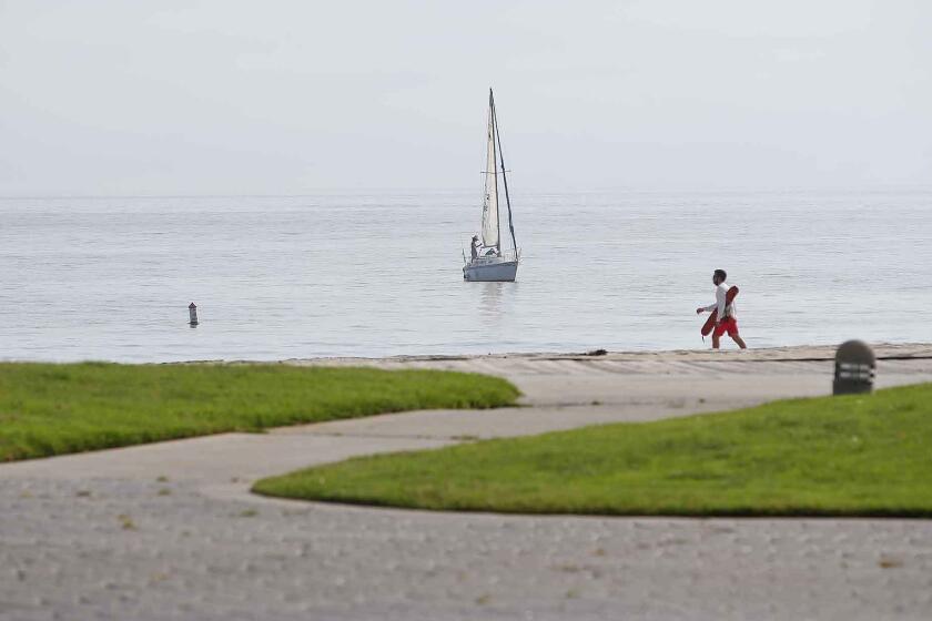 Paths and the grass remain empty, as only a lifeguard and sailboat occupied Main Beach on Sunday as Laguna Beach city beaches remained closed as some surrounding cities ease closure restrictions, while maintaining Covid-19 safety protocols in Orange County.
