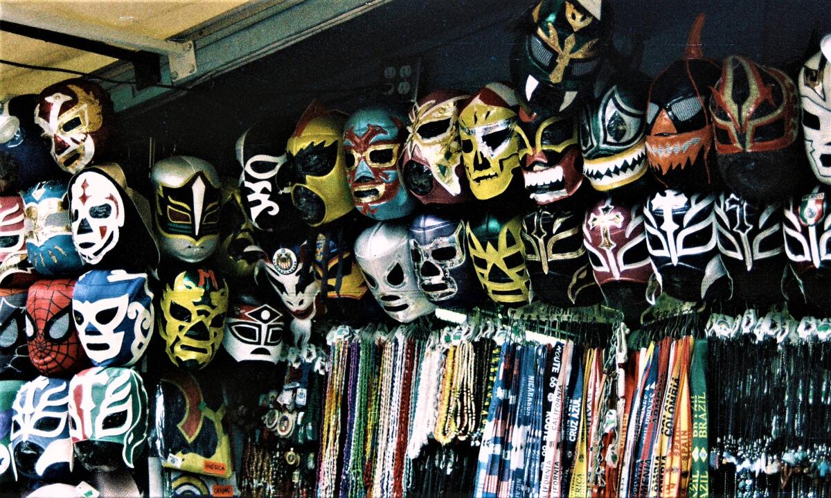 Lucha libre masks are displayed for customers at a stand on Olvera Street in Los Angeles.