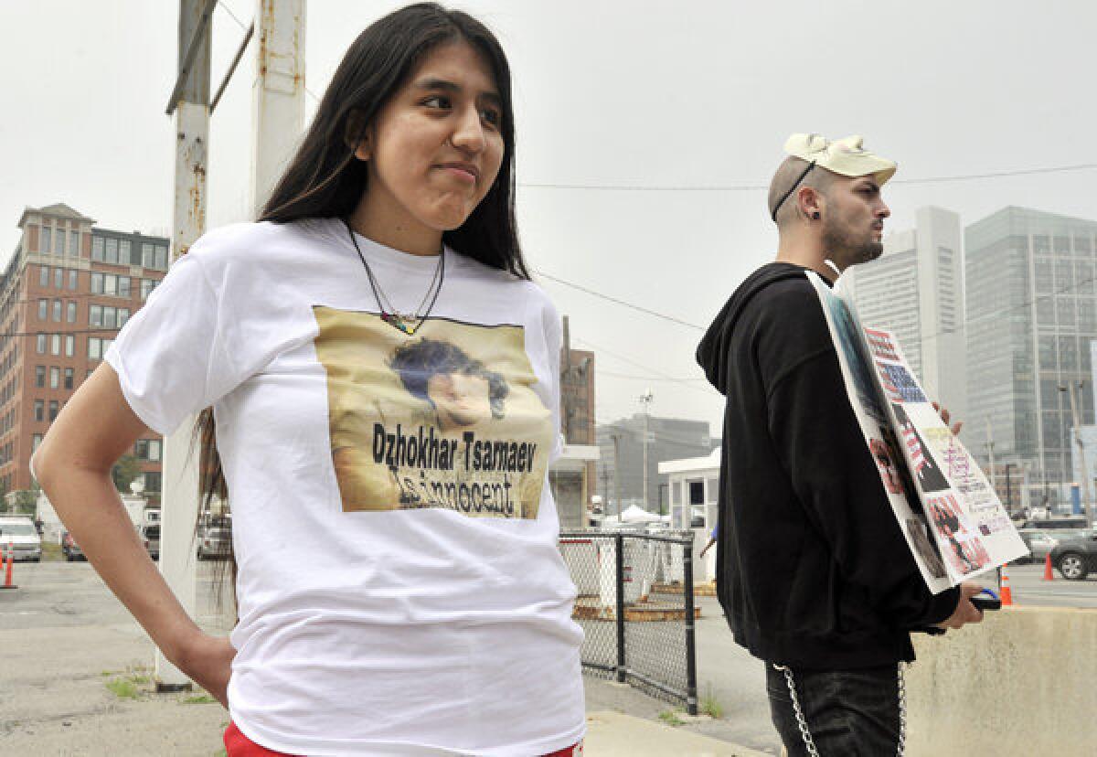 Jennifer Michio, left, from Mashantucket, Conn., and Duke La Touf, right, of Las Vegas, stand in support of Boston Marathon bombing suspect Dzhokhar Tsarnaev outside the federal courthouse before his arraignment Wednesday in Boston.