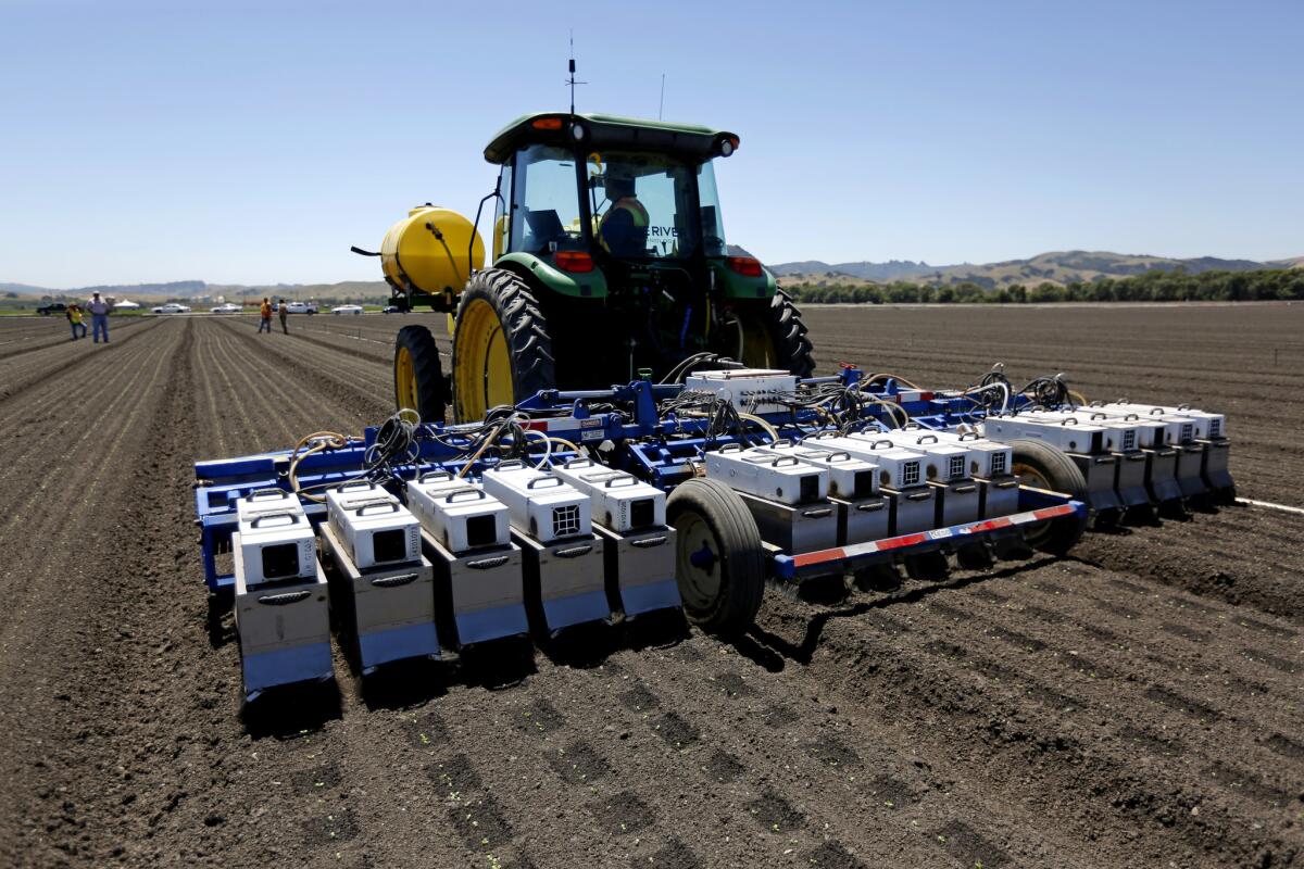 A See and Spray machine manufactured by Blue River Technology uses cameras, computers and precision sprayers to thin a lettuce field in Gilroy, Calif., in May.