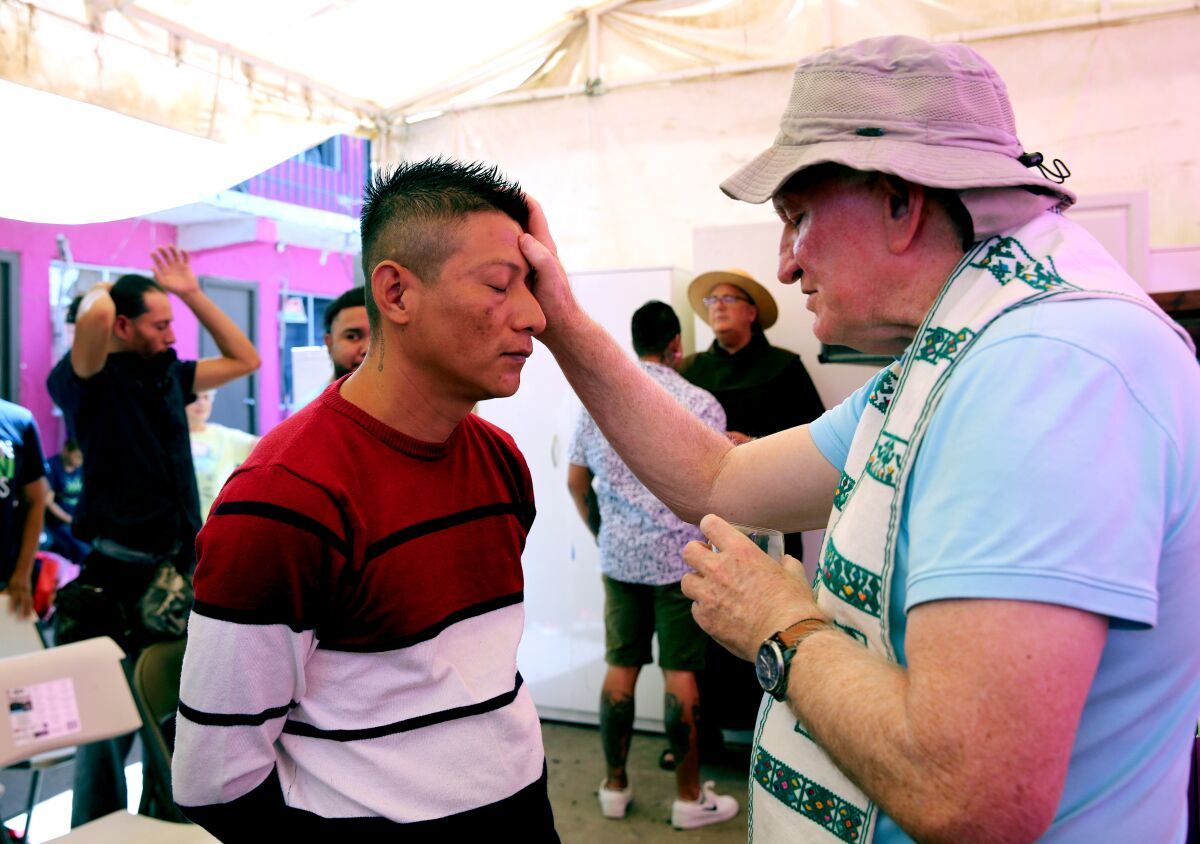 Father Jay Cunnane blesses Eric Palacios.