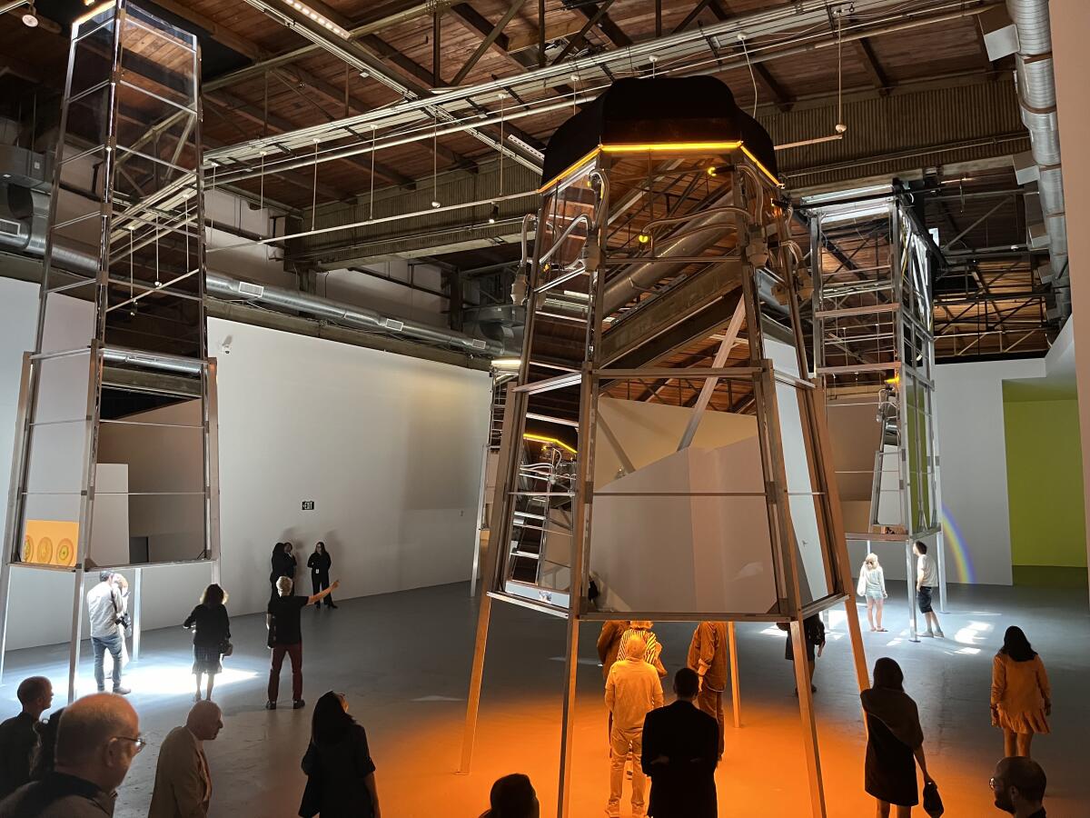 Visitors at the Geffen Contemporary at MOCA step under monumental mirrored towers that provide kaleidoscopic views inside. 