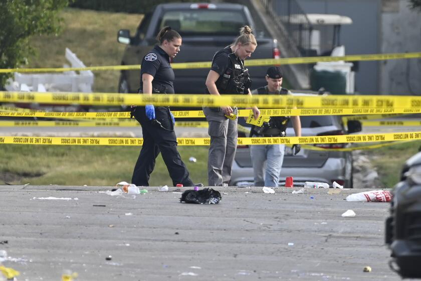 Investigators look over the scene of an overnight mass shooting at a strip mall in Willowbrook, Ill., Sunday, June 18, 2023. (AP Photo/Matt Marton)