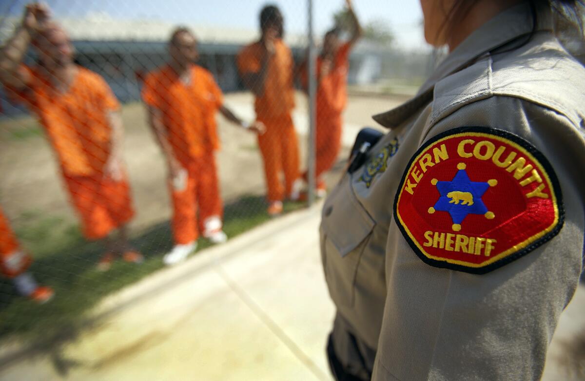 Detention Deputy Tanja Young, right, talks with inmates in the yard at the Kern County Sheriff's Office Lerdo Detention Facility in Bakersfield.