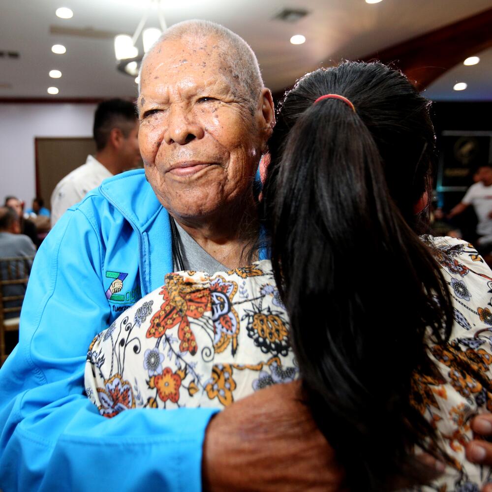 Ignacio Mendoza, 90, hugs a woman.