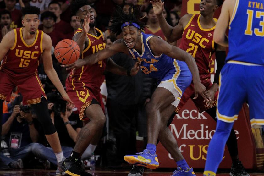 LOS ANGELES, CA - MARCH 7, 2020: UCLA Bruins forward Jalen Hill (24) loses the ball as he's triple teamed by USC Trojans forward Isaiah Mobley (15), USC Trojans guard Daniel Utomi (4), and USC Trojans forward Onyeka Okongwu (21) in the second half at Galen Center on March 7, 2020 in Los Angeles, California. USC won 54-52. (Gina Ferazzi/Los AngelesTimes)