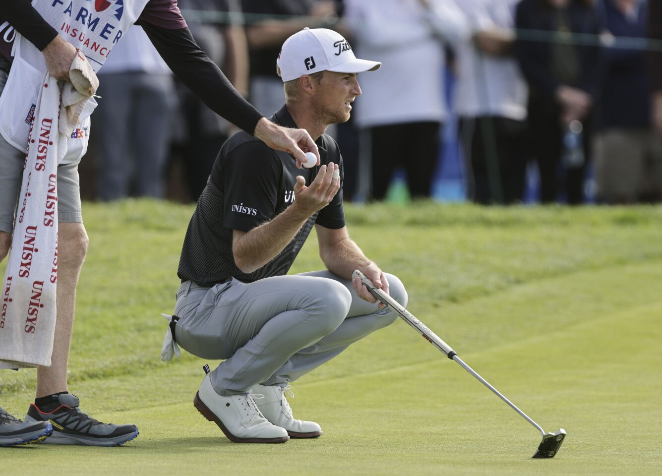 Will Zalatoris gets a ball from his caddie as he prepares to putt on the South Course's 13th green during the third round of the Farmers Insurance Open on Jan. 28.