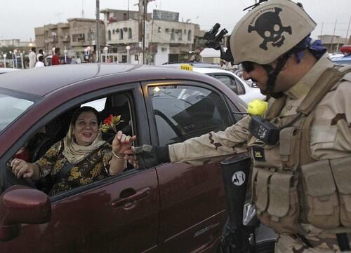 A driver gives a flower to an Iraqi soldier on June 30, the day U.S. troops pulled out Iraqi cities under a security pact. The Iraqi government has kept U.S. forces out of cities since, making no requests for help, even with major attacks.