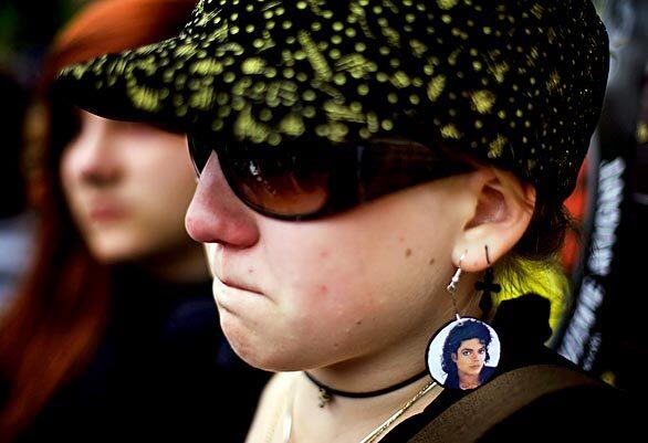 A Polish woman wearing earrings sporting a portrait of Jackson mourns his death in downtown Warsaw.