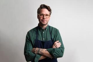 Chef Marcus Jernmark stands in a collared shirt and an apron, arms crossed and looking at camera