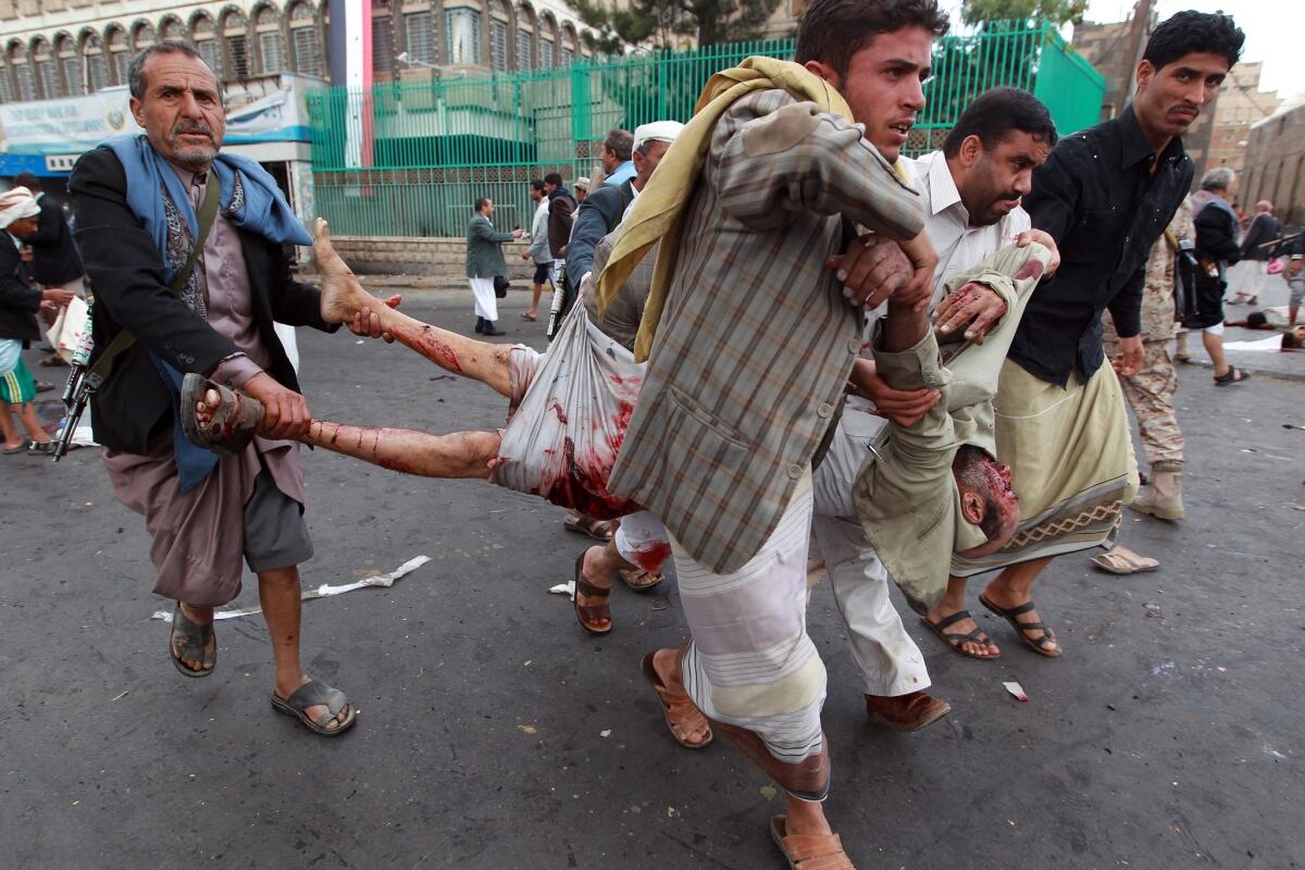 Yemeni Shiite Houthi militiamen carry a victim of a suicide bombing that rocked Sana, the capital, on Oct. 9.