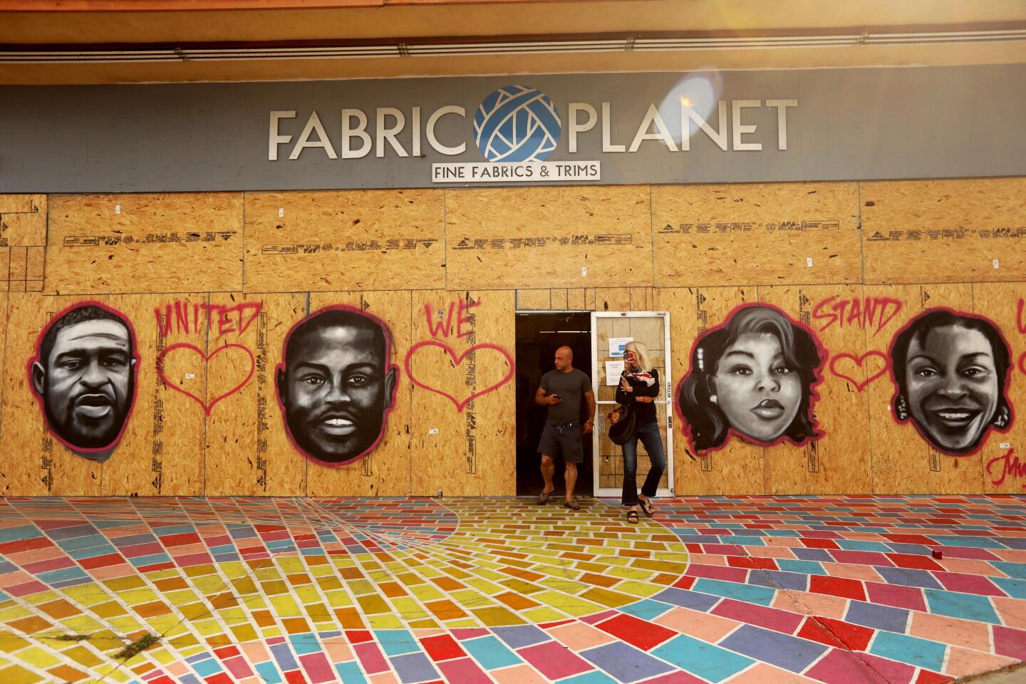 Jack Sapar, owner of Fabric Planet in Venice, walks out of his business with a customer.