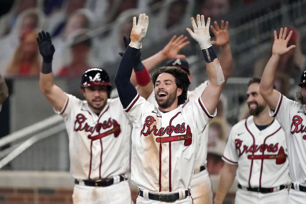 Atlanta Braves shortstop Dansby Swanson, center, celebrates after hitting a walk-off two-run home run in the ninth inning of a baseball game against the Washington Nationals Monday, Aug. 17, 2020, in Atlanta. (AP Photo/John Bazemore)