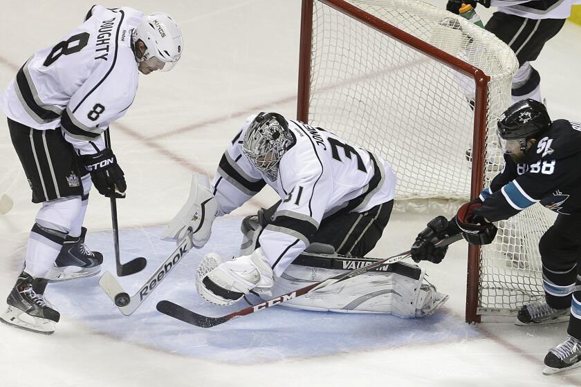 Kings goalie Martin Jones, who replaced Jonathan Quick, covers a rebound between defenseman Drew Doughty and Sharks winger Brent Burns after blocking a shot in the third period.