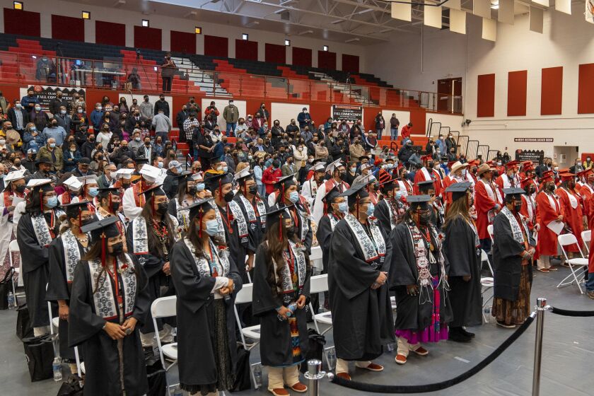 In this photo provided by Navajo Technical University, graduates at the school stand during a ceremony in Crownpoint, N.M., Dec. 16, 2022. On Friday, March 24, 2023, school officials said the creation of a doctoral program focused on Dine culture and language marks a milestone for the university and is the first doctoral program among tribal colleges and universities in the United States. (Wafa Hozien/Navajo Technical University via AP)