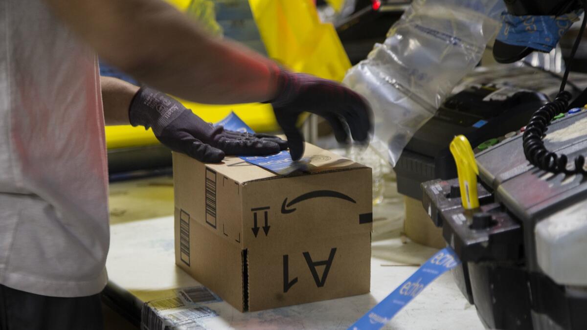 A worker at an Amazon fulfillment center in San Bernardino in 2016. Amazon recently raised its base wage to $15 an hour while cutting bonuses and stock plans.