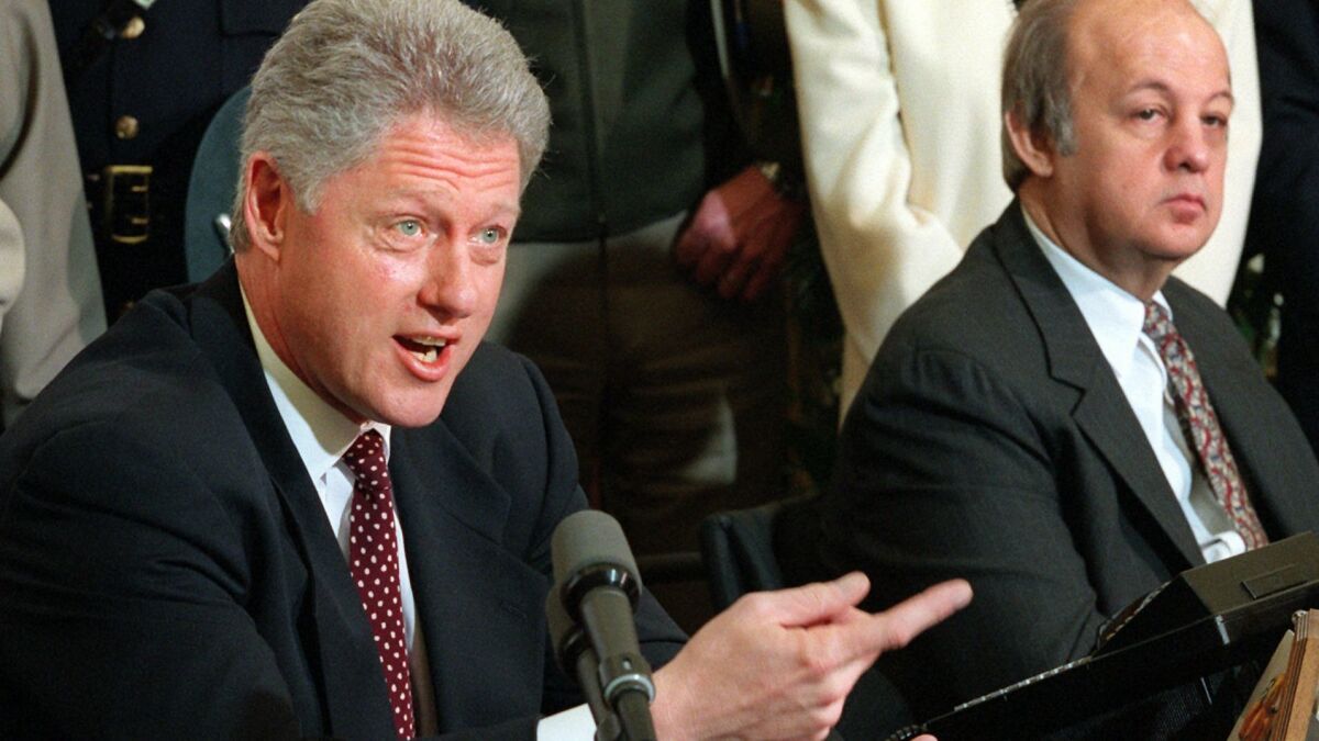Then-President Clinton holds a news conference on March 5, 1997 to talk about clamping down on gun sales to foreigners. At right is former President Ronald Reagan's press secretary James Brady.
