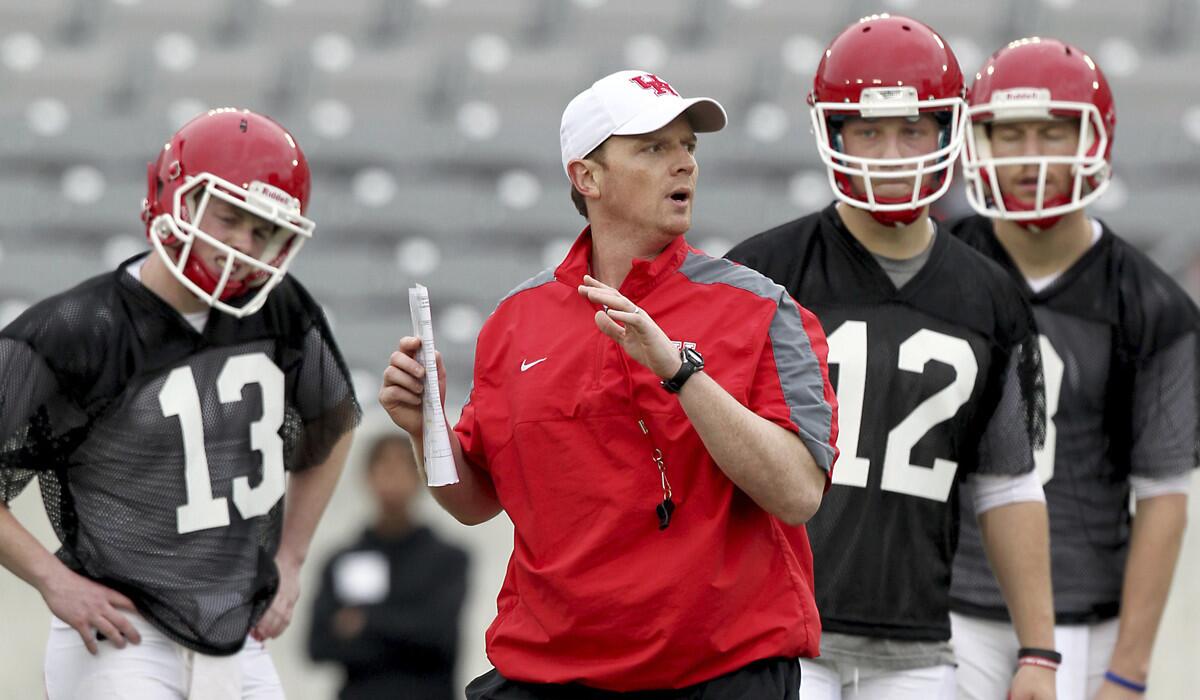 Houston quarterbacks listen to Coach Major Applewhite demonstrate a foot drill during spring practice on March 10, 2015. Applewhite was hired to replace Tom Herman as coach at Houston on Friday.