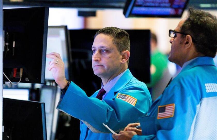 Varios trabajadores de la Bolsa contemplan los indicadores de mercado en una pantalla en Nueva York (Estados Unidos). EFE/Archivo