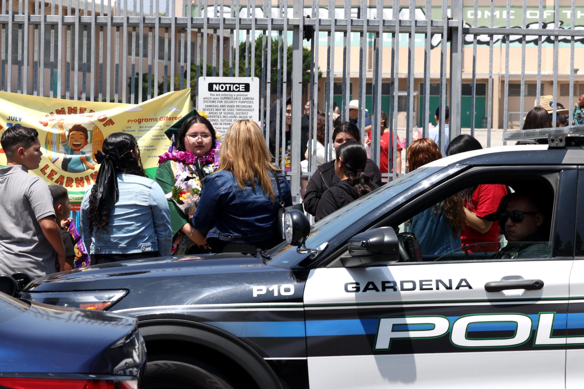 police officers keep a watchful eye out as Gardena High School graduates mingle with family and friends