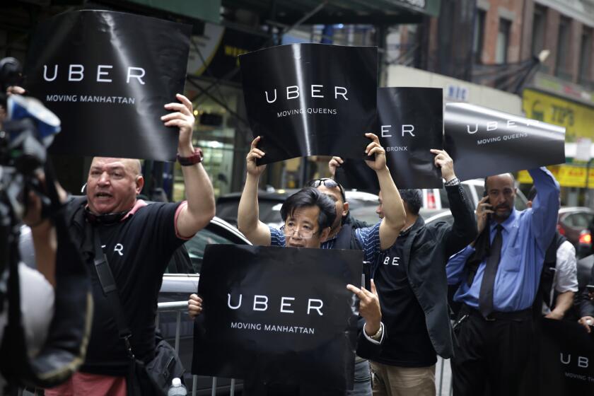 Uber drivers and their supporters protest in front of the offices of the Taxi and Limousine Commission in New York in May.