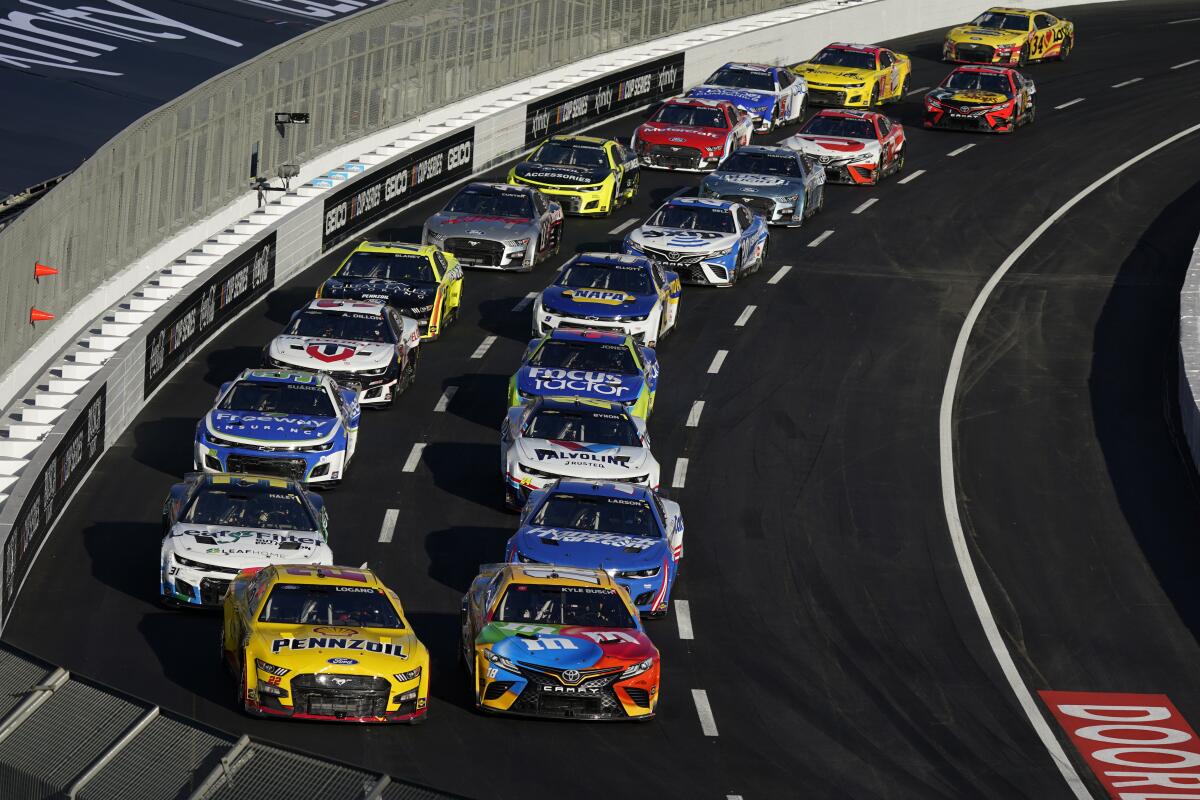 NASCAR drivers Joey Logano, left, and Kyle Busch lead the field in a turn during the Clash at the Coliseum.