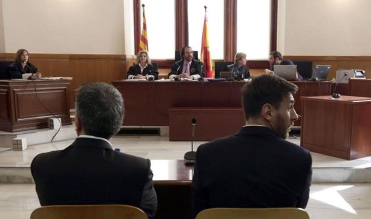 Lionel Messi (d) y su padre Jorge Horacio Messi (i) en la sala de la Audiencia de Barcelona durante la jornada del juicio contra ellos por delitos contra la Hacienda Publica.