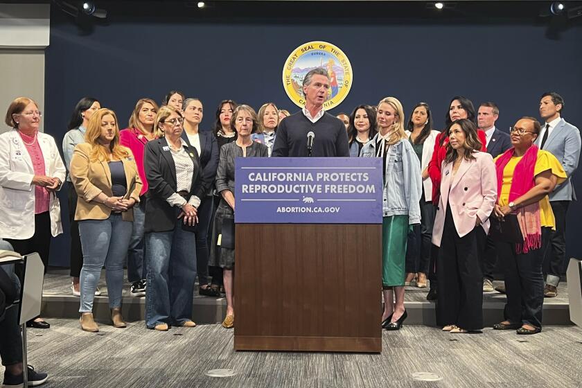 Joined by the state Legislative Women's Caucus and advocates, California Gov. Gavin Newsom, center, speaks during a news conference, Wednesday, April 24, 2024, in Sacramento, Calif., to announce legislation that would help Arizona women access abortions. The proposal would circumvent a ban on nearly all abortions in Arizona by allowing Arizona doctors to give their patients abortions in California. (AP Photo/Sophie Austin)