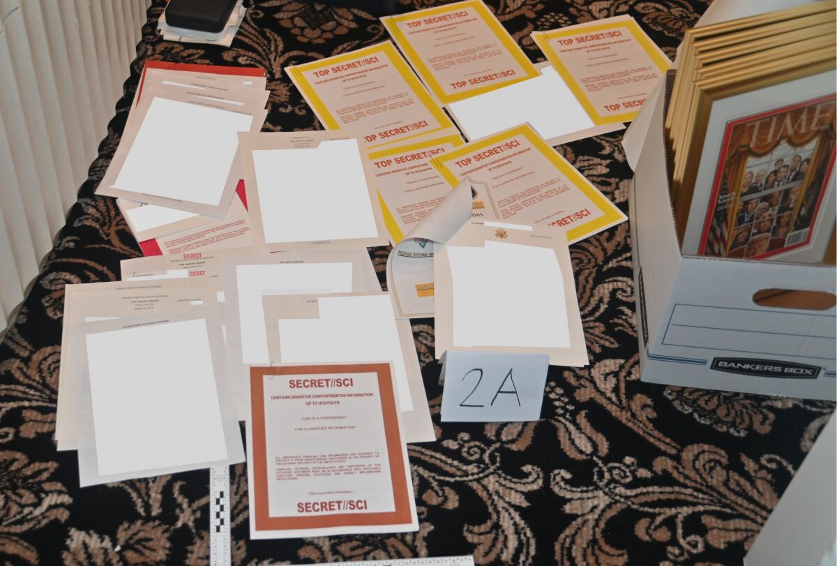 A photo of classified documents spread out on a carpet with arabesques.
