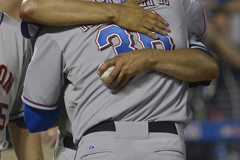 Texas Rangers reliever Joe Nathan is hugged by Mariano Rivera of the New York Yankees after closing out the American League's 3-0 victory over the National League in the MLB All-Star Game on Tuesday.