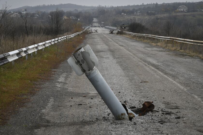 A tail of a multiple rocket sticks out of the ground near the recently recaptured village of Zakitne, Ukraine, Wednesday, Nov. 9, 2022. This was the year war returned to Europe, and few facets of life were left untouched. Russia’s invasion of its neighbor Ukraine unleashed misery on millions of Ukrainians, shattered Europe’s sense of security, ripped up the geopolitical map and rocked the global economy. The shockwaves made life more expensive in homes across Europe, worsened a global migrant crisis and complicated the world’s response to climate change. (AP Photo/Andriy Andriyenko)