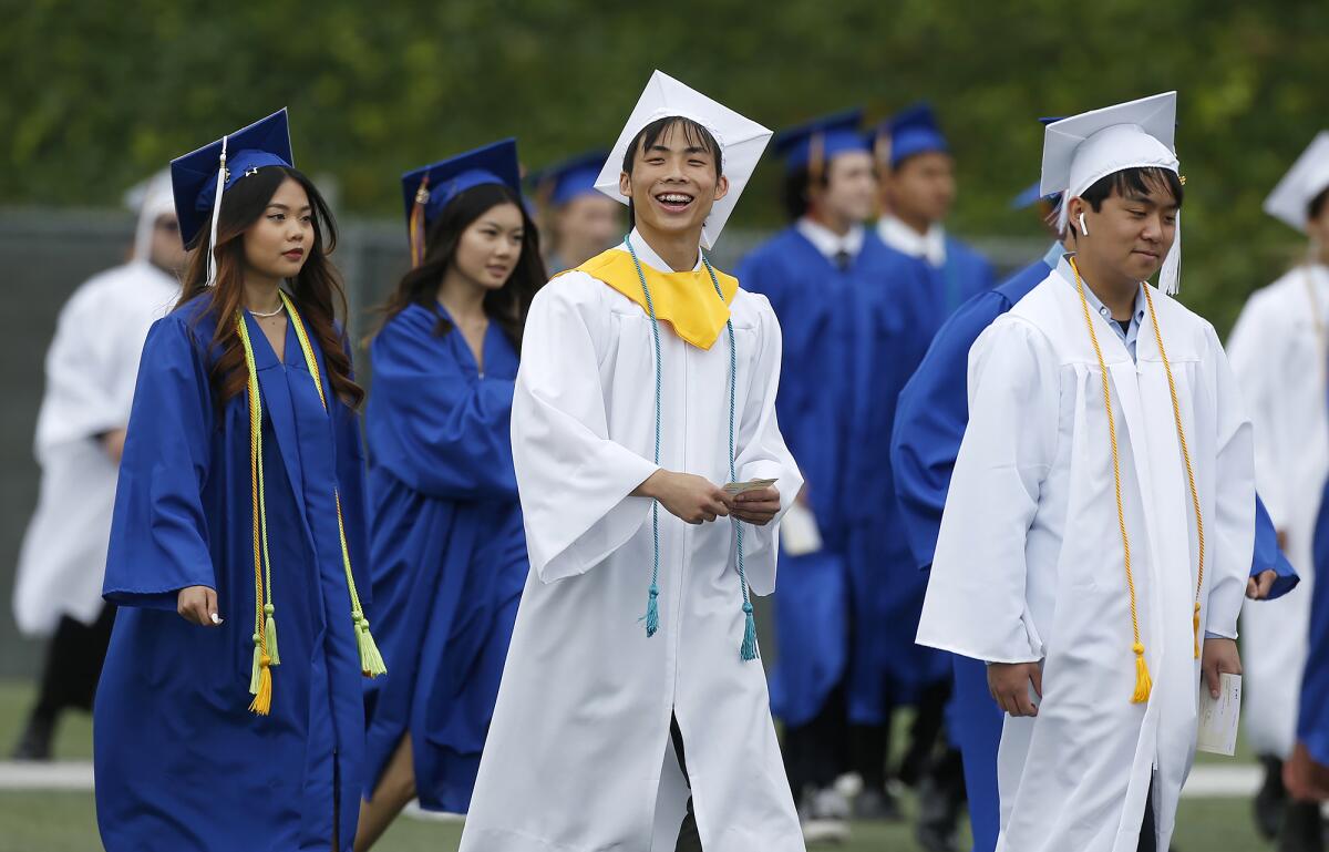 Proud graduates take the field as they parade into the 2023 Fountain Valley High graduation ceremony on Wednesday.